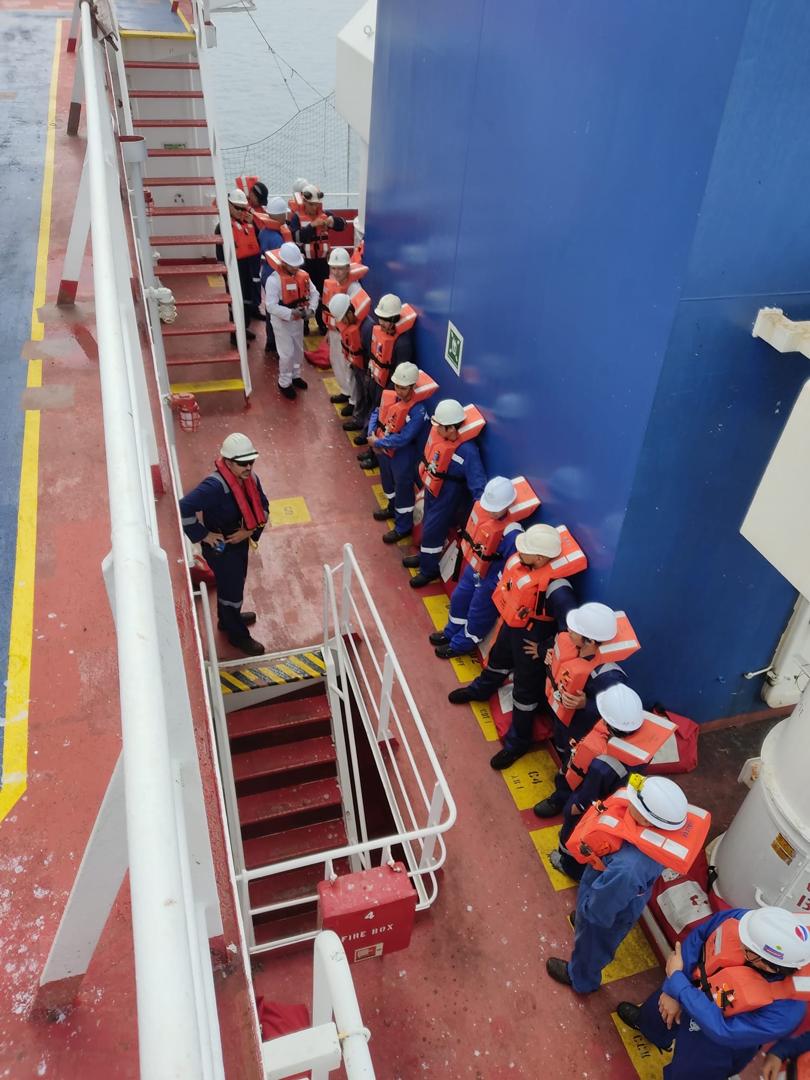 Crew muster drill with lifejackets assembled on a vessel deck